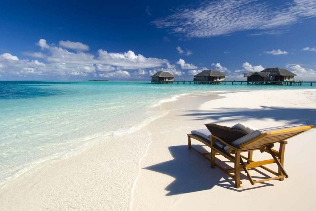white sand beach with lounger and luxury accommodation